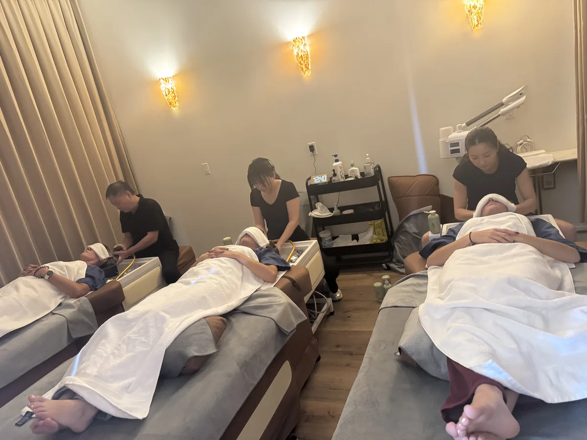 A second view of the head spa room at Elite Spa Utah, with clients resting under towels as therapists treat the scalp and neck